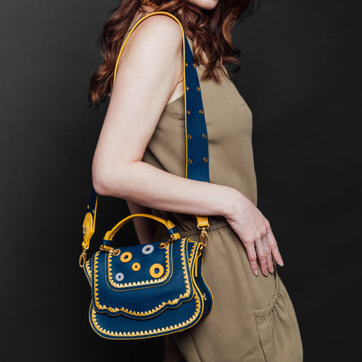 Woman wearing blue designer crossbody bag over the shoulder