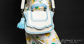 Designer Audrey crossbody bag made from white Italian leather with pastel blue trim.