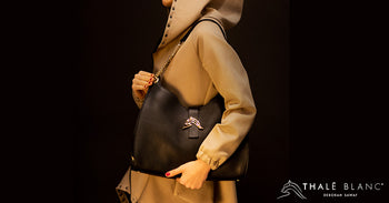 Woman in camel jacket carrying designer shoulder bag made from brown embossed Italian leather.