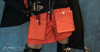 Women's designer shorts in orange with large quilted cargo-style pockets in front.