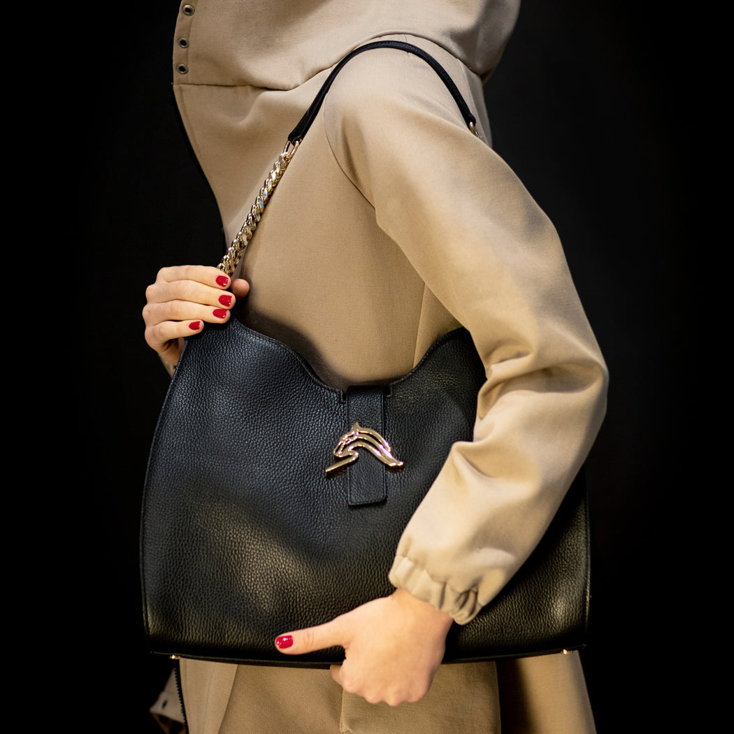 Woman carrying designer shoulder bag in black leather