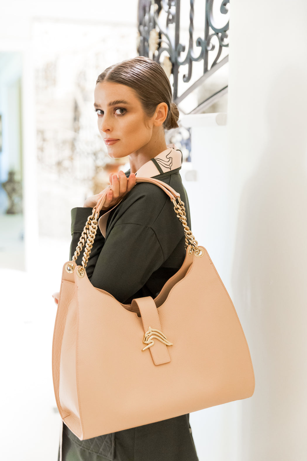 Woman carrying a designer hobo bag in nude-pink leather