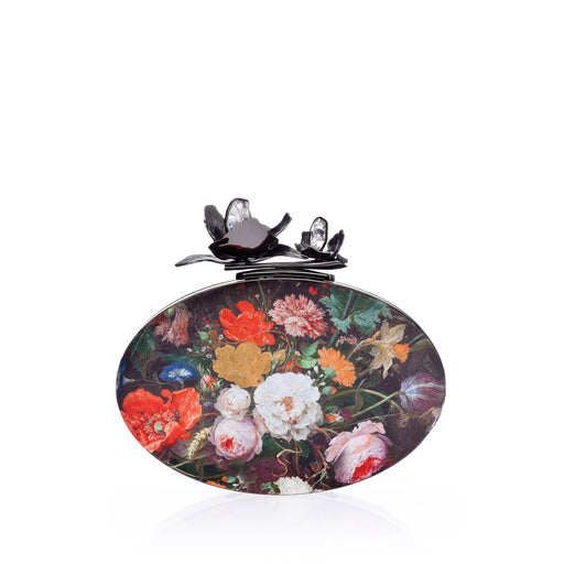 An edgy luxury evening clutch in Bouquet Silk Jacquard, the Oval Bloom features a gunmetal orchid and crystal stones. A detachable wrist chain is included. Designed to fit just the essentials.