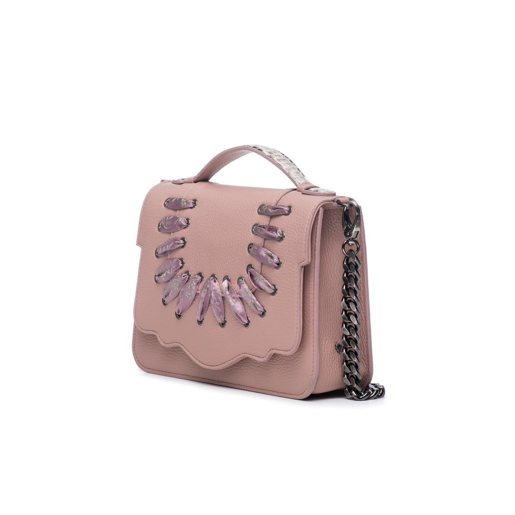 This best-selling top handle luxury leather bag in blush pebbled calfskin features both a detachable crossbody leather strap and a detachable chain strap. Make it your own with a fur Duma Hok-Pom or our signature leather tassel or opt for one of our leather guitar straps for an on-trend look. It is one of the easiest to accessorize handbags.