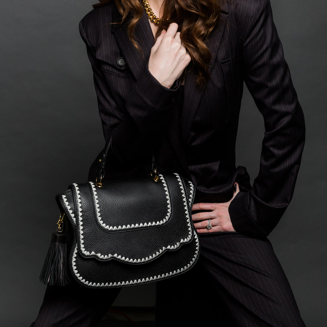 Female model holding black satchel purse