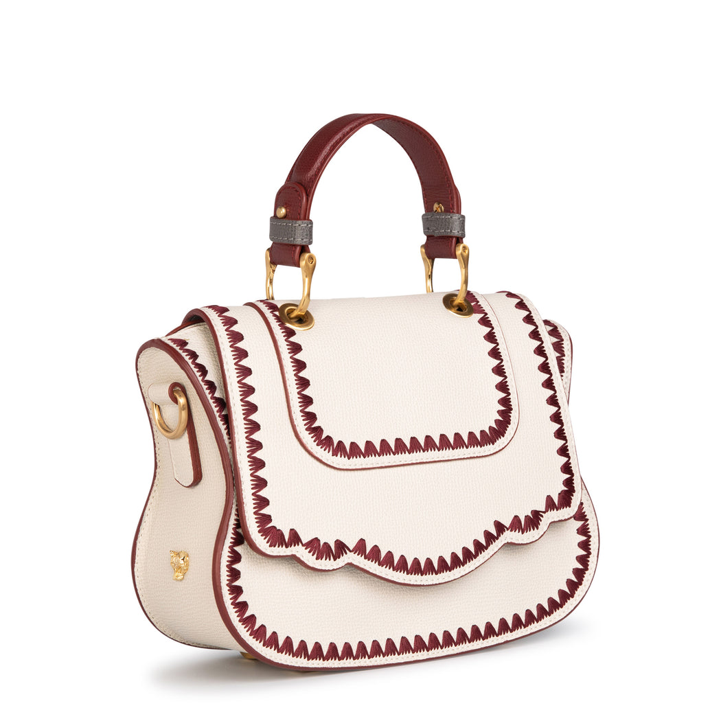 Women's designer handbag in white leather with red stitching