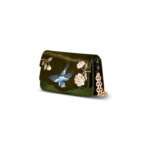 The Audreyette Small Couture luxury handbag can be worn a number of different ways. This green silk pony and green smooth calf leather bag features a powder-coated chain with detachable fur detail, embroidered floral and bird motif, and can be worn as a crossbody with detachable strap. It is one of the easiest to accessorize handbags.