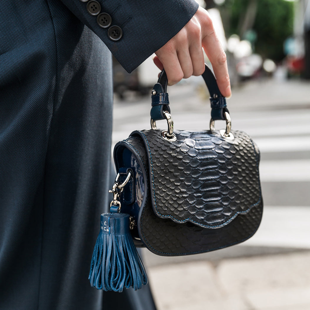 Woman carrying midnight blue snakeskin print crossbody handbag